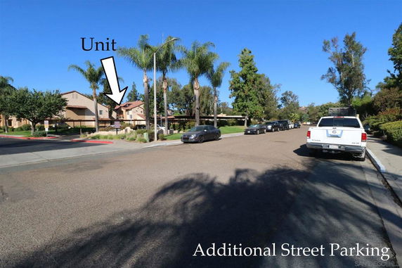 Street with parked vehicles in a residential area, showing additional street parking.
