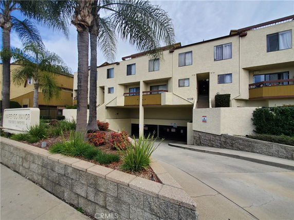 Front view of a multi-story residential building with a parking entrance.