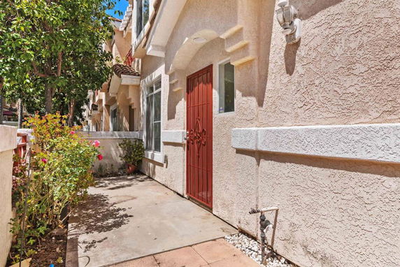 Front view of a house with a red door and stucco exterior.