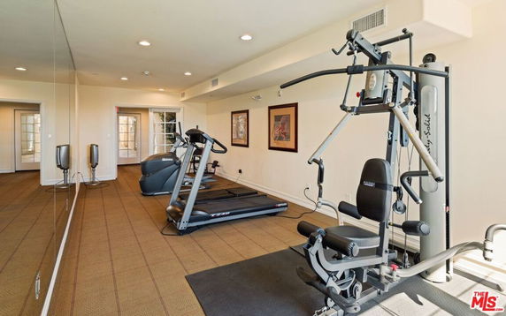 Indoor gym area with exercise equipment including a treadmill and multi-gym machine.