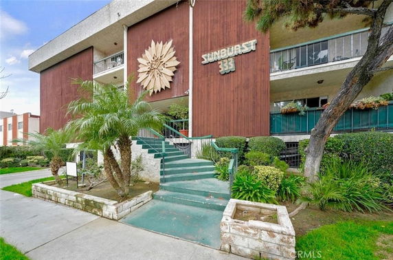 Front view of a multi-story building with a large decorative emblem and balconies.