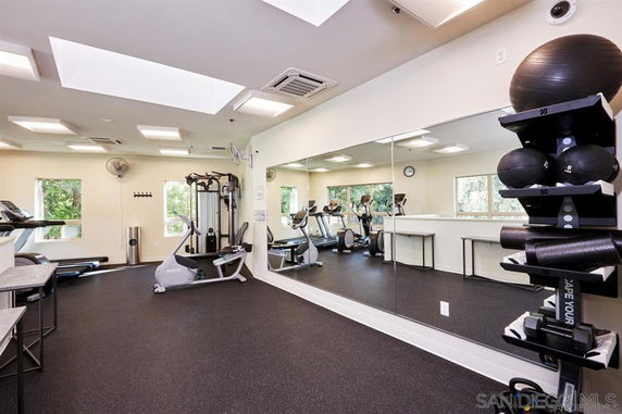 Interior of a gym with exercise equipment and mirrors.
