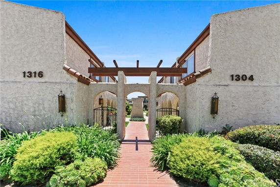 Front view of a two-story building with stucco exterior and archway entrance.