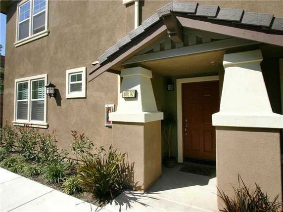Front view of a house with a brown exterior and a small porch entrance.