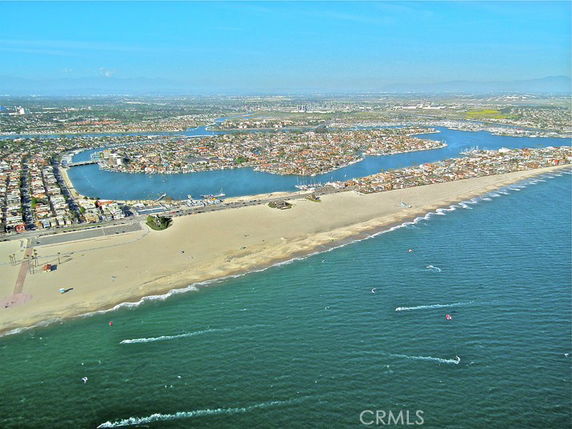 Aerial view of a coastal city with beaches, water bodies, and dense residential areas.