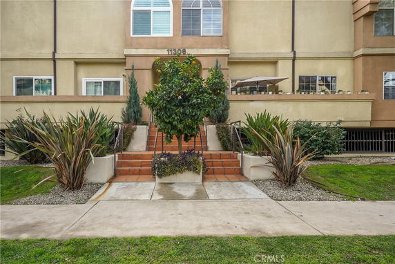 Front view of a residential building with steps leading to the entrance.