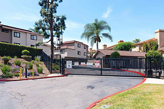 Front view of a gated residential complex with multiple two-story buildings.