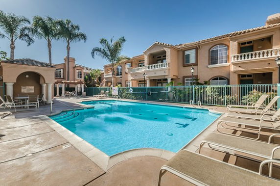 Outdoor swimming pool area with surrounding residential buildings.