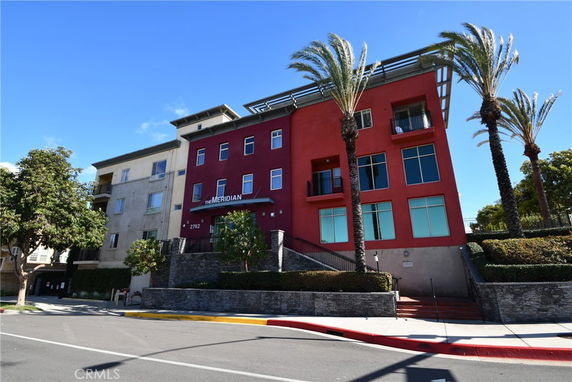 Front view of a multi-story building with a modern facade and prominent windows.