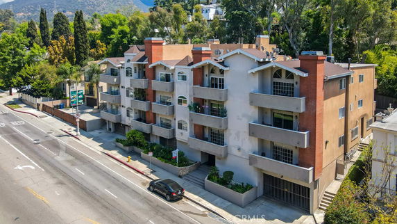 Front view of a multi-story apartment building with balconies and brick accents.