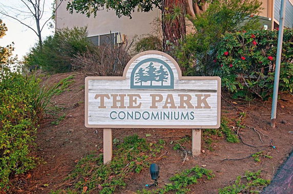 Signboard for The Park Condominiums with plants around.