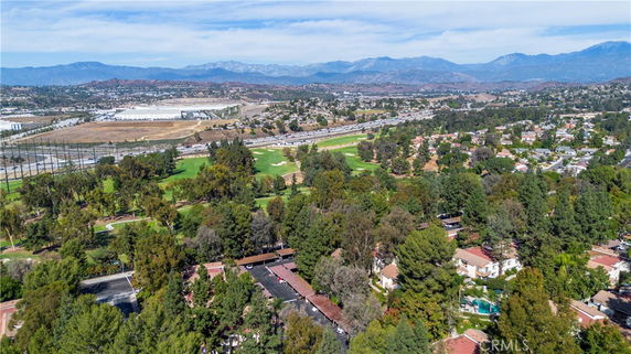 Panoramic view of suburban area with houses, golf course, and distant mountains.