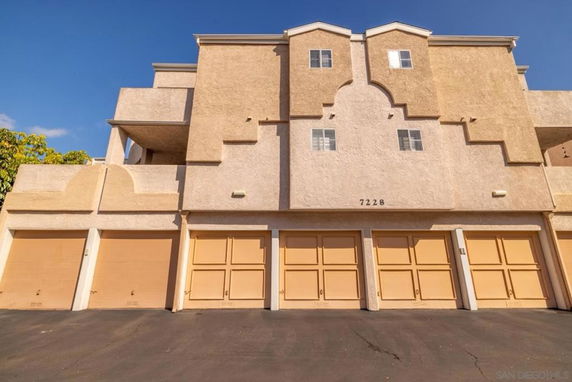 Front view of a multi-story apartment building with multiple garages.