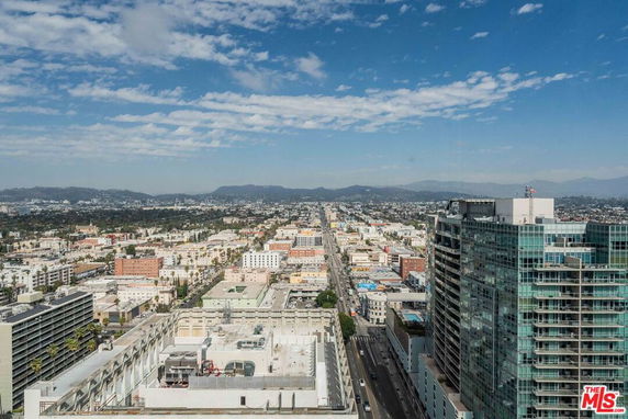 Panoramic view of a cityscape with buildings and distant mountains.