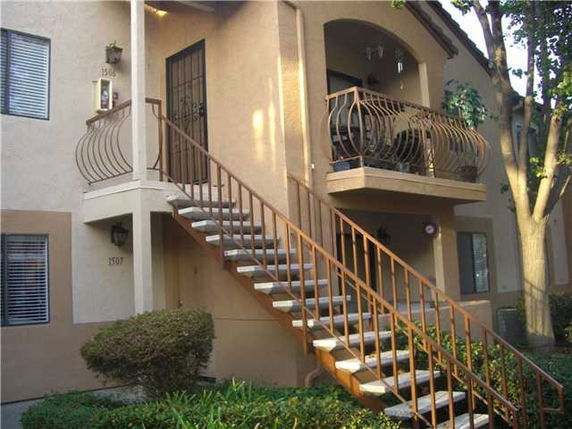 Front view of a multi-story building with exterior stairs and balconies.