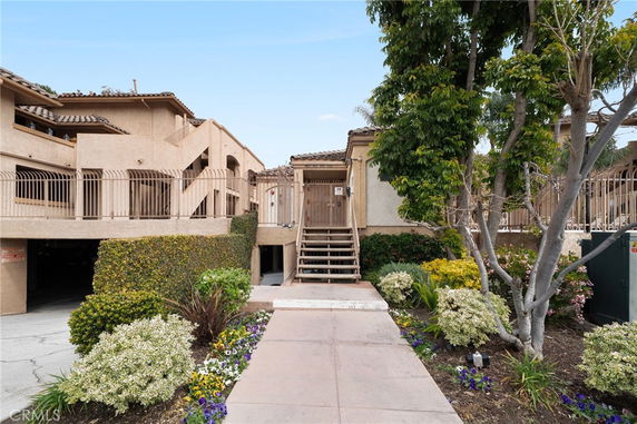 Front view of a two-story residential building with exterior stairs and balconies.