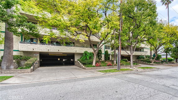 Front view of a multi-story residential building with a gated entrance.