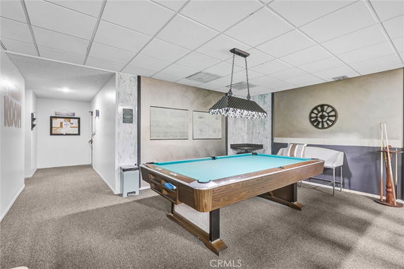 Indoor room with a billiards table and hanging lights.