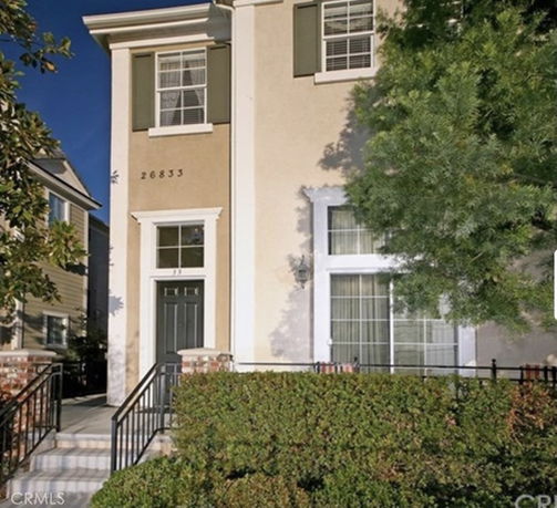 Front view of a two-story house with large windows and a dark-colored front door.