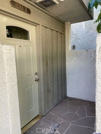 Front view of a house entrance with a light-colored door and textured walls.