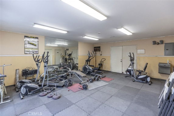 Indoor gym area with exercise equipment and mirrors on the wall.