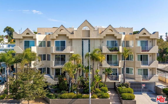 Front view of a multi-story apartment building with balconies.