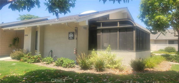 Front view of a single-story house with a screened porch.