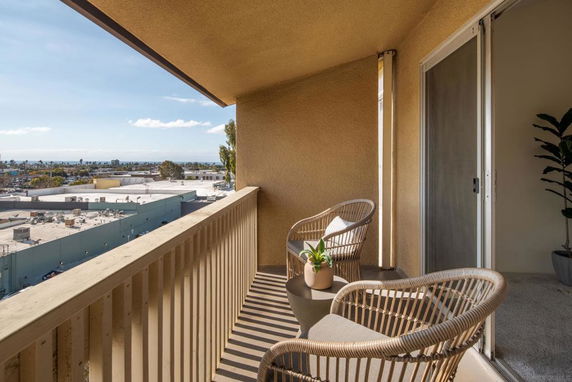 Balcony view overlooking a cityscape with buildings and distant horizon.