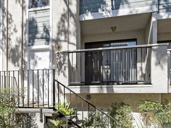 Front view of a residential building with a balcony and entrance door marked number 29.