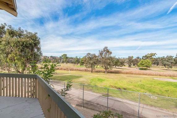 Panoramic view of a grassy area with trees seen from a balcony.