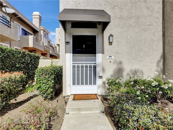 Front view of a residential entrance with a screen door and awning.