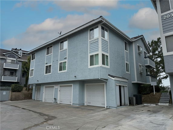 Front view of a three-story building with multiple garage doors.