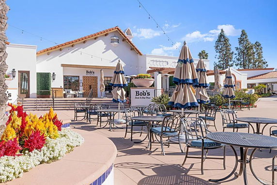 Front view of a building with outdoor seating and umbrellas.