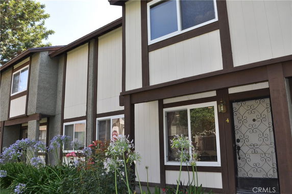 Front view of a two-story house with brown trim and white siding.