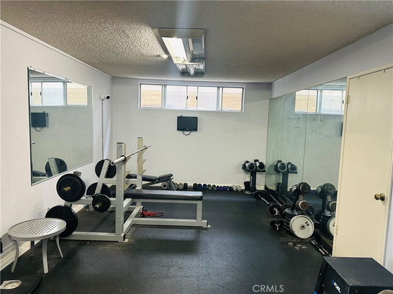 Indoor gym area with weights and mirrors.