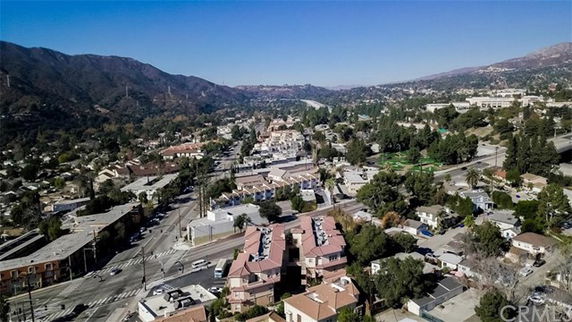 Wide angle view of a residential area with roads and mountains in the background.