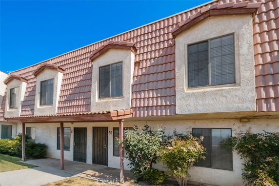Front view of a two-story residential building with shingle roofing and multiple windows.