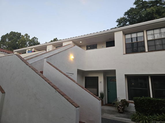 Front view of a two-story building with stairs leading to upper units.