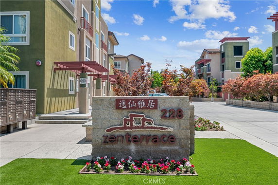 Front view of a multi-story residential building with a signpost reading 'zen terrace' at the entrance.