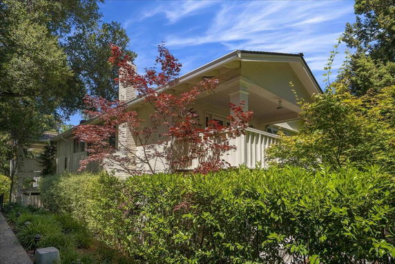 Front view of a house with a covered porch and white railing.
