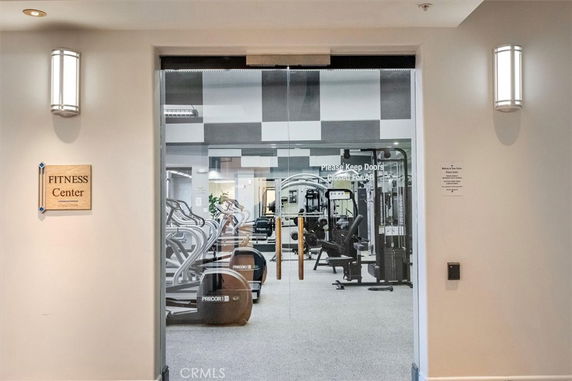 Entrance to a gym with fitness equipment visible inside.