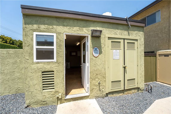 Front view of a small utility building with an open door.