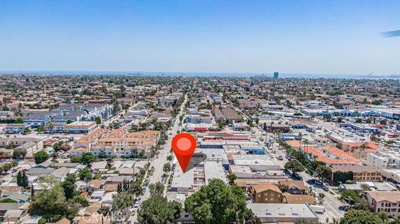 Panoramic view of a cityscape with a red marker indicating a specific location.