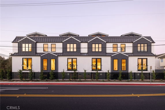 Front view of a multi-story building with a modern design and multiple dormer windows.