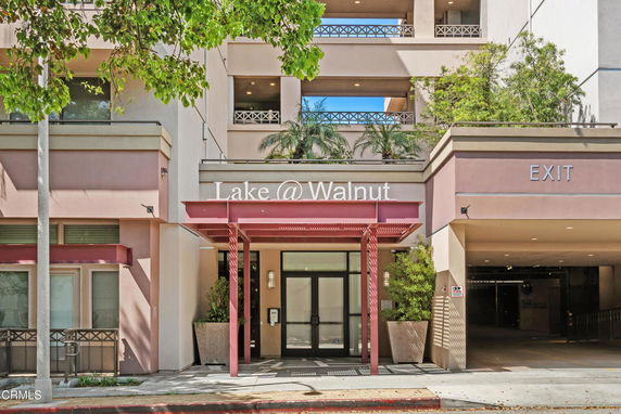 Front view of a multi-story building entrance labeled 'Lake @ Walnut' with an adjacent parking exit.