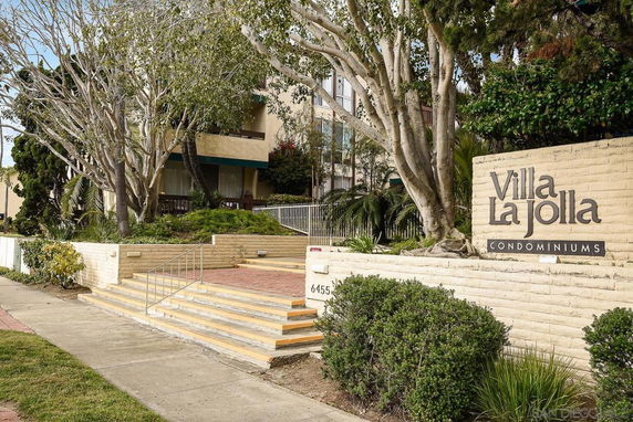 Front view of a condominium building with a staircase entrance.