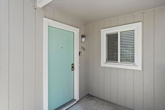 Front view of an entrance with a light blue door and adjacent window in a building.