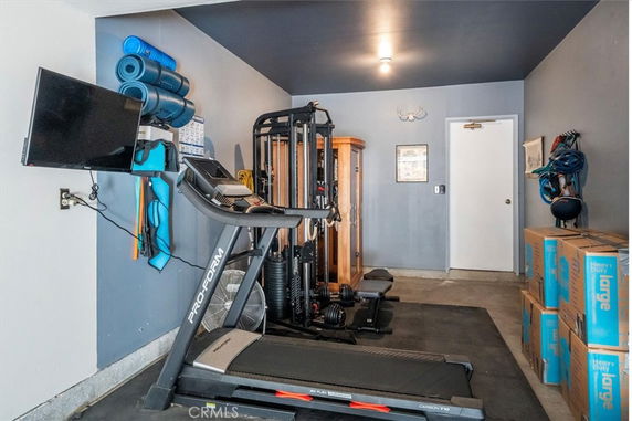Indoor gym area with exercise equipment and storage boxes