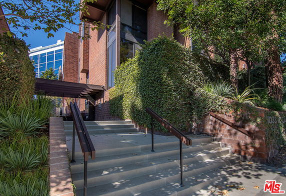 Front view of a brick building with stairs leading to the entrance.