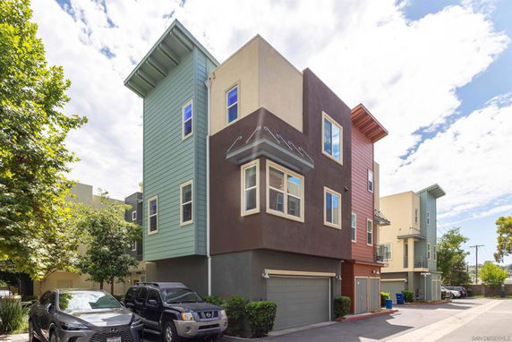Front view of a multi-story modern building with colorful exterior and garages.